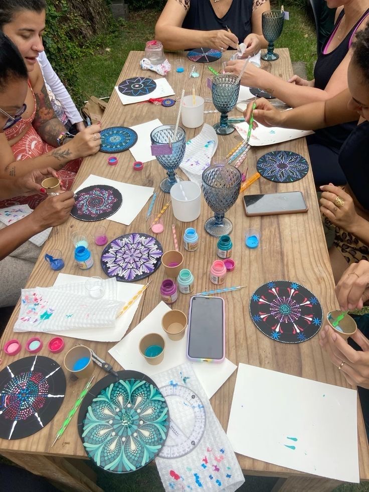 Taller de arteterapia: mujeres pintando mandalas en una mesa de madera al aire libre